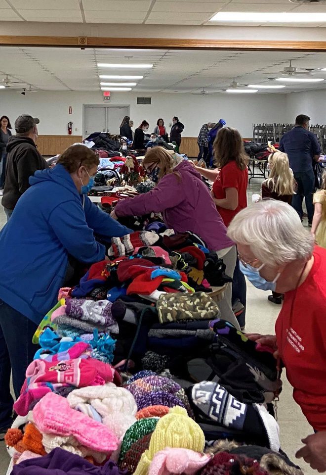 Community Involvement - View of Elderly Women Wearing Masks Sorting Through Coats Gloves and Hats During Coat Drive Charity Event with Simon Insurance