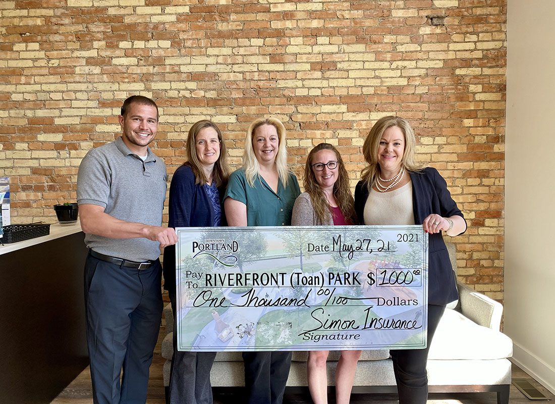 Community Involvement - Portrait of Simon Insurance Agency Staff in the Office Holding Up a Donation Check to Riverfront Park